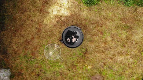 Round-Barbeque-Grill-With-Coal-And-Fire-In-The-Backyard