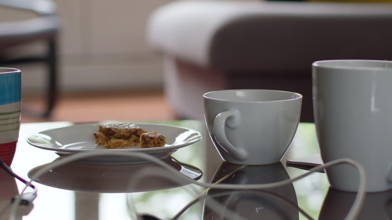 노트북을 사용하는 사람이 간식과 연결 케이블을 가지고 집에서 테이블에서 뜨거운 음료를 가져오는 근접 사진