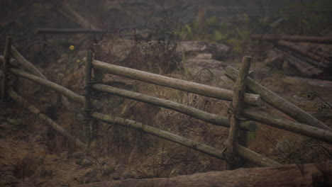 an old wood fence with a country field behind it