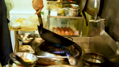 chef skillfully cooks with a wok in kitchen