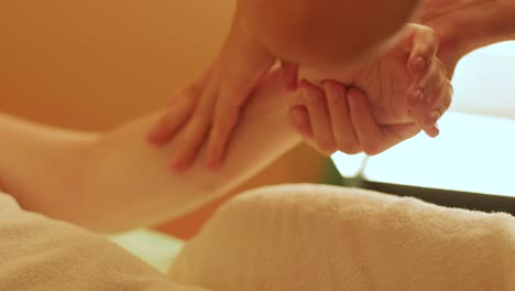 shot of a professional massage therapist massaging the client's hands and arms. woman getting full body massage at relaxing wellness spa