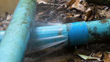 close up shot of old blue pvc pipes leaking water