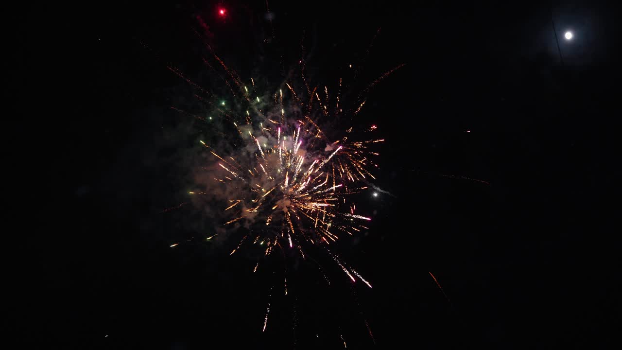 Colorati fuochi d'artificio esplodono nel cielo notturno durante una festa, creando un'atmosfera vivace e gioiosa