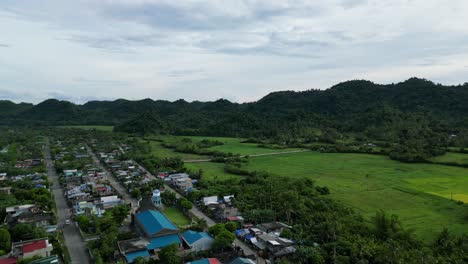 Panning-shot-of-a-small-island-barangay-town-captures-the-beauty-of-rural-and-urban-life,-with-ocean-views-adding-to-the-charm