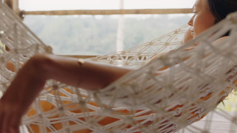 woman in hammock enjoying comfortable lifestyle on vacation in holiday resort swaying peacefully on lazy summer day in tropical paradise cabin 4k