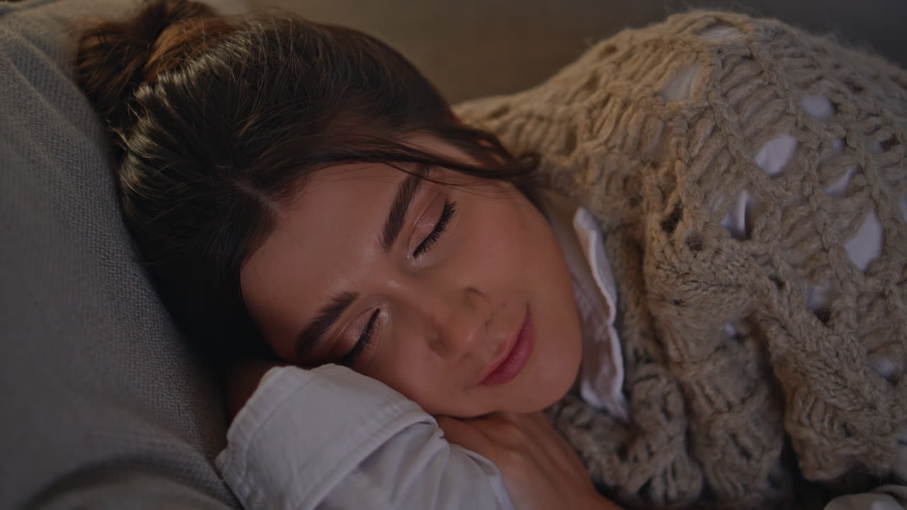 클로즈업 잠자는 소녀 저녁 아파트. tv 빛에 소파에서 휴식을 취하는 여성