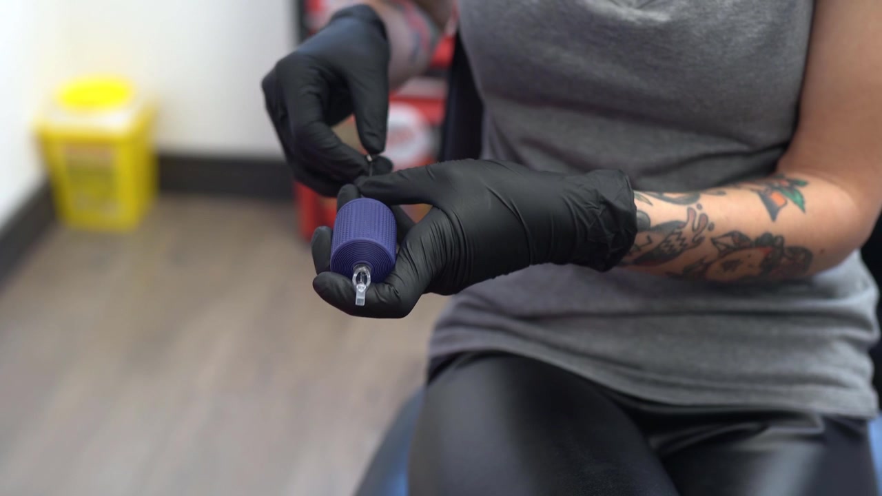 Tatuatrice che smonta la macchinetta per tatuaggi.