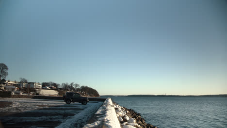 Peaceful-moring-mood-at-the-water-side-winter-snow-ice-cold-freezing-jeep-at-fjord