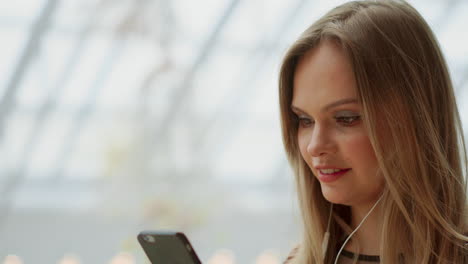 happy teenage girl holding bags with purchases, smiling while looking at phone in shopping center. received good news, reading message, texting. horizontal photo banner for website header design