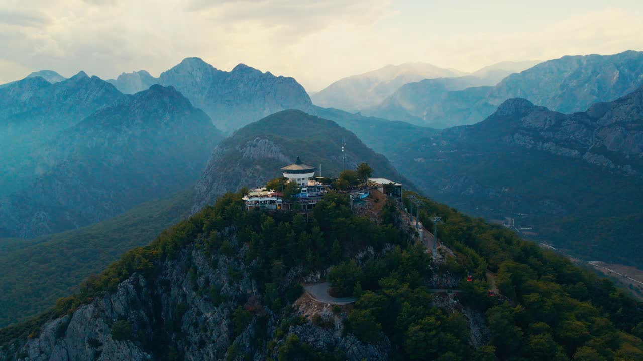 video aéreo 4k de un drone de una estación de cable de tunektepe teleferik posicionada en la cima de la colina con las montañas en el fondo
