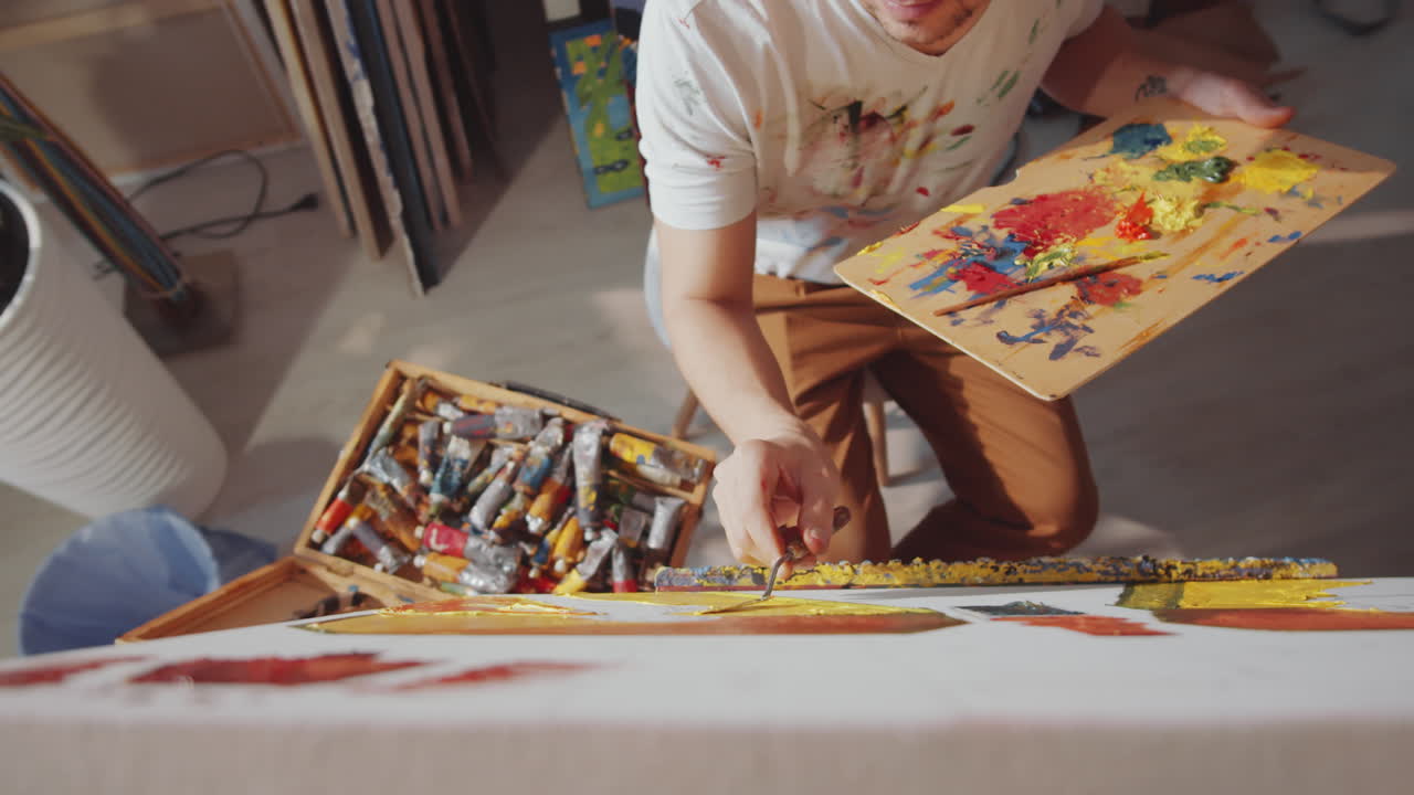 팔레트 칼로 그림을 그리는 예술가의 위쪽 전망