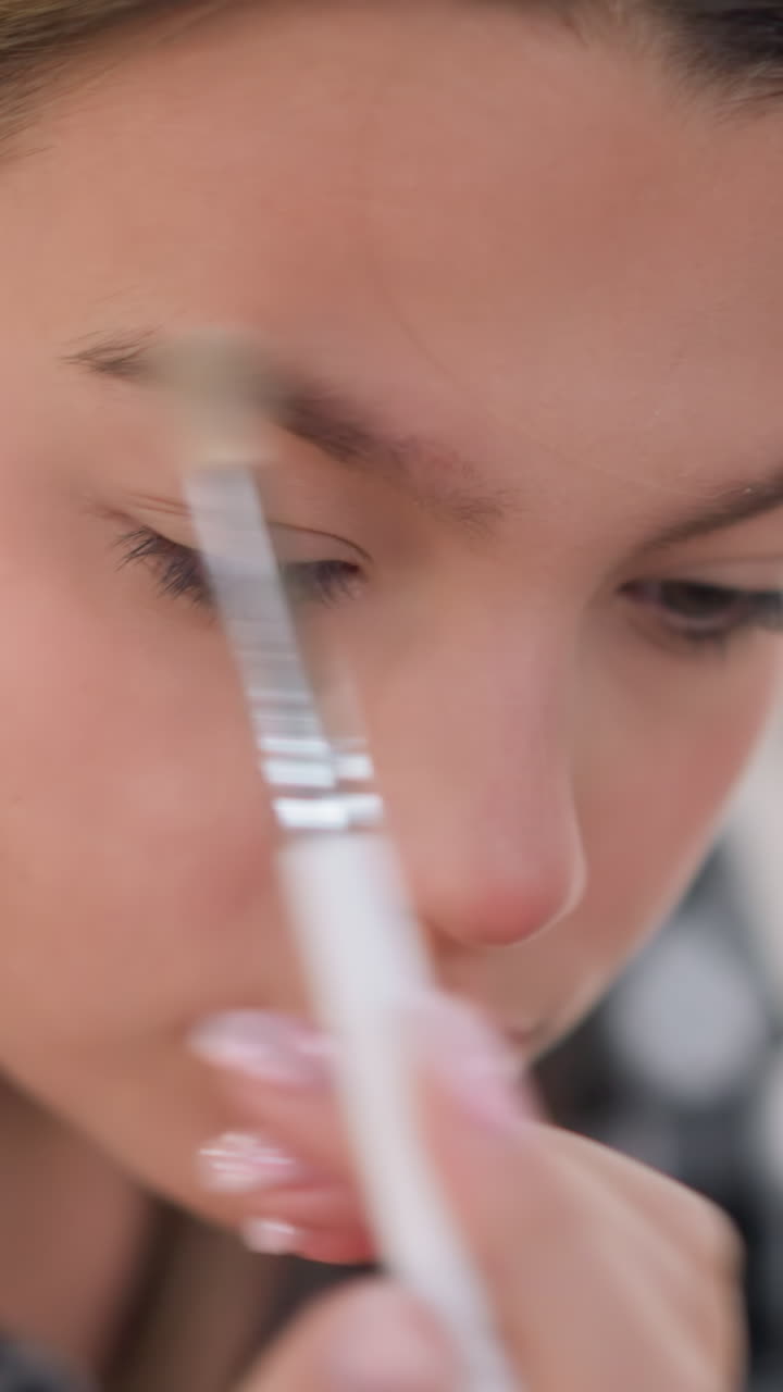 Closeup of soft glam eyelid application, Practicing warm toned eye makeup with precise brush strokes, Detailed tutorial on subtle eye shadow blending using fluffy brushes and patient movements