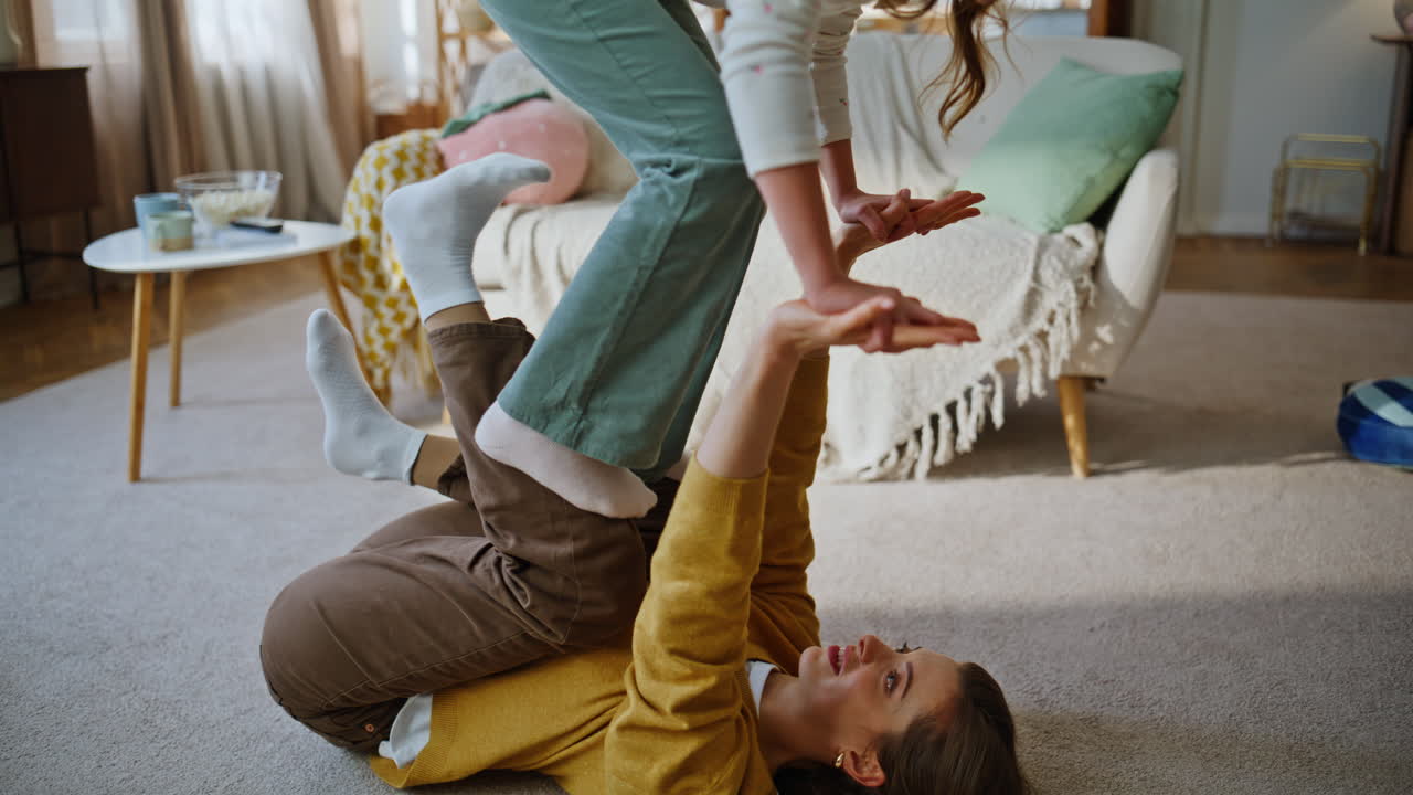 Mom kid family yoga exercise room closeup. Woman lying soft carpet raising girl