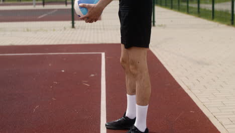 vista lateral del hombre moreno golpeando una pelota de voleibol.