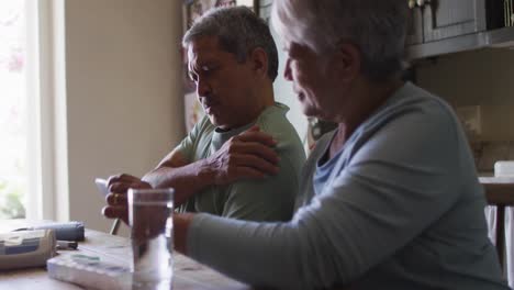 senior mixed race couple having online medical consultation using smartphone