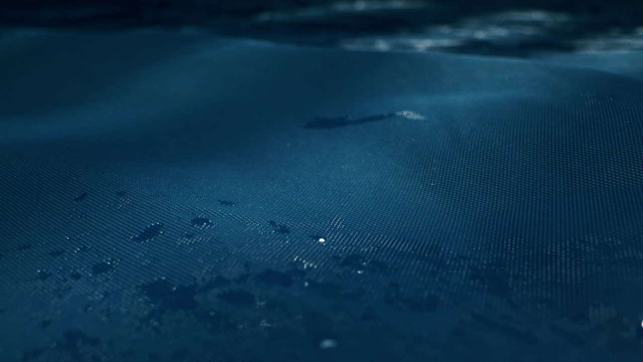 A serene water surface with gentle ripples and glistening raindrops in calming blue hues, creating peace