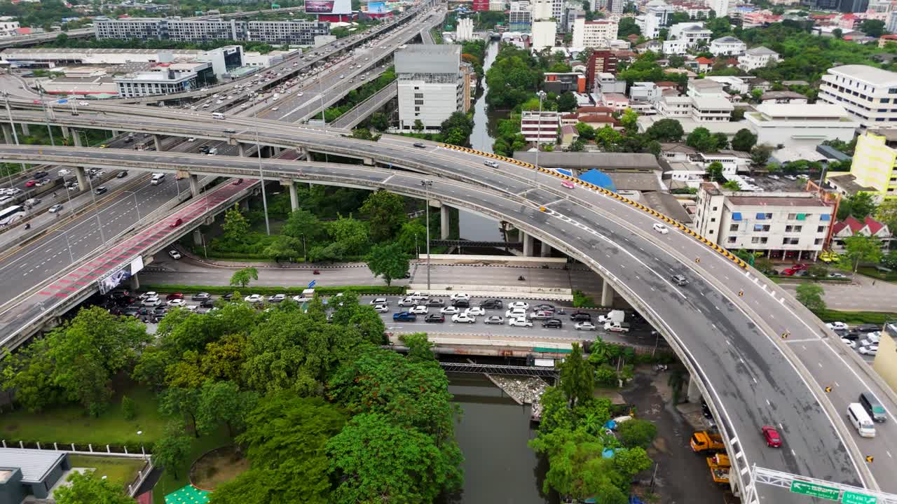 Aerial drone shot cars driving on overpass in large urban Asian city