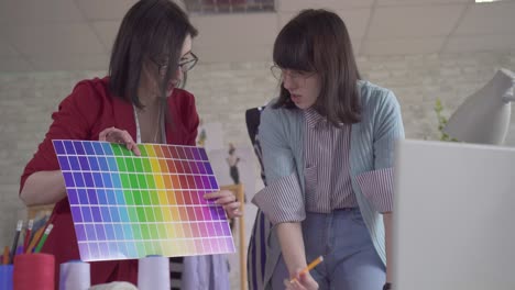 two fashionable young fashion designer at work in the studio