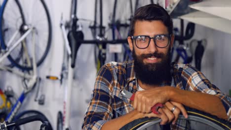 Porträt-Eines-Mechanikers-Mit-Fahrrad-In-Der-Werkstatt