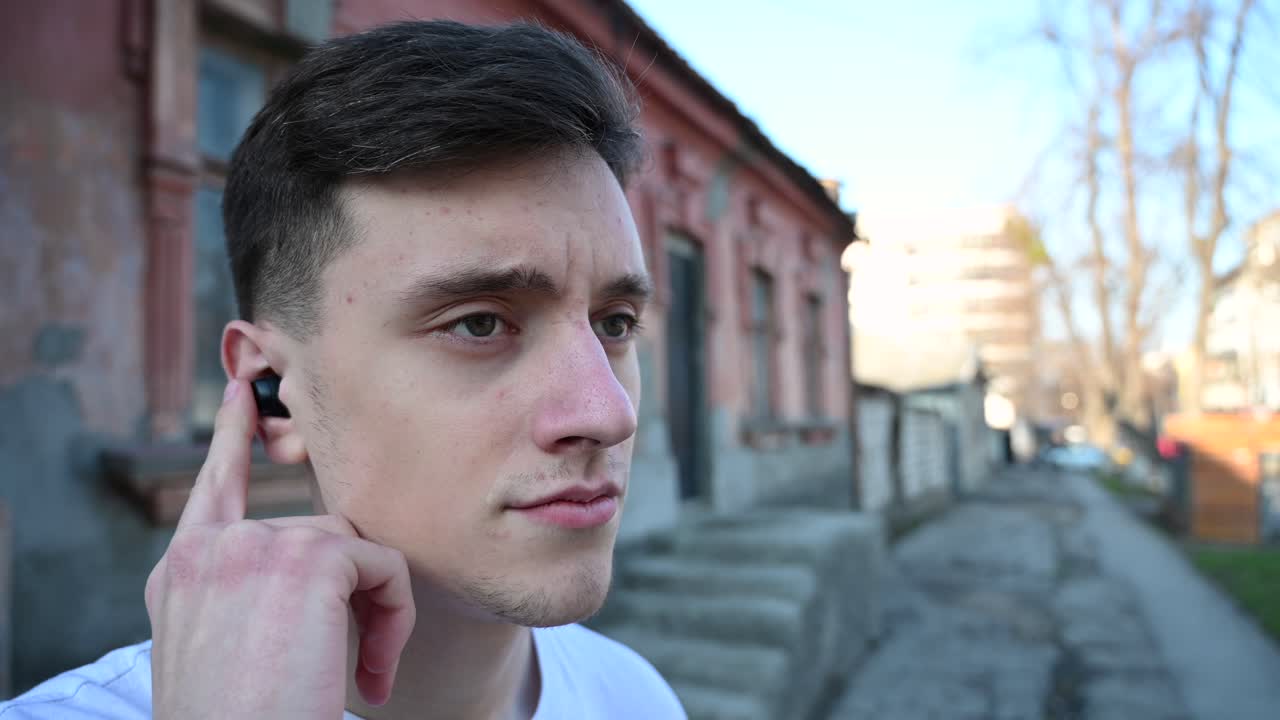 Man hands using touch gestures on black wireless earbuds