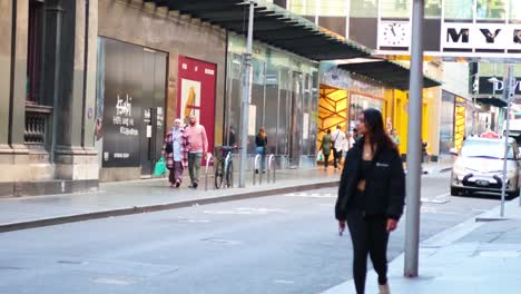 woman walks past department store in melbourne