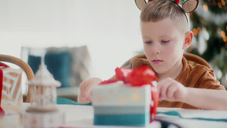 primer plano de un niño envolviendo regalos de navidad