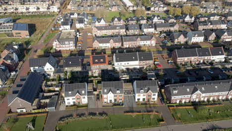 High-angle-aerial-of-a-modern-suburban-neighborhood-with-rooftops-filled-with-solar-panels