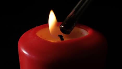 red candle burning on black background. red wax candle burning. close-up. infinitely flame of candles. isolated.