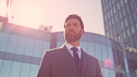 ambitious manager standing sunlight street closeup. confident businessman posing