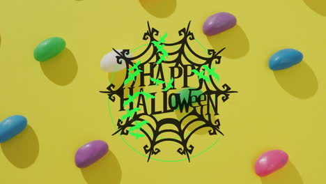 happy halloween text animation over colorful candies on yellow background