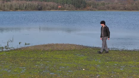 Joven-Arrojando-Piedras-Al-Lago---Disparo-De-Drone