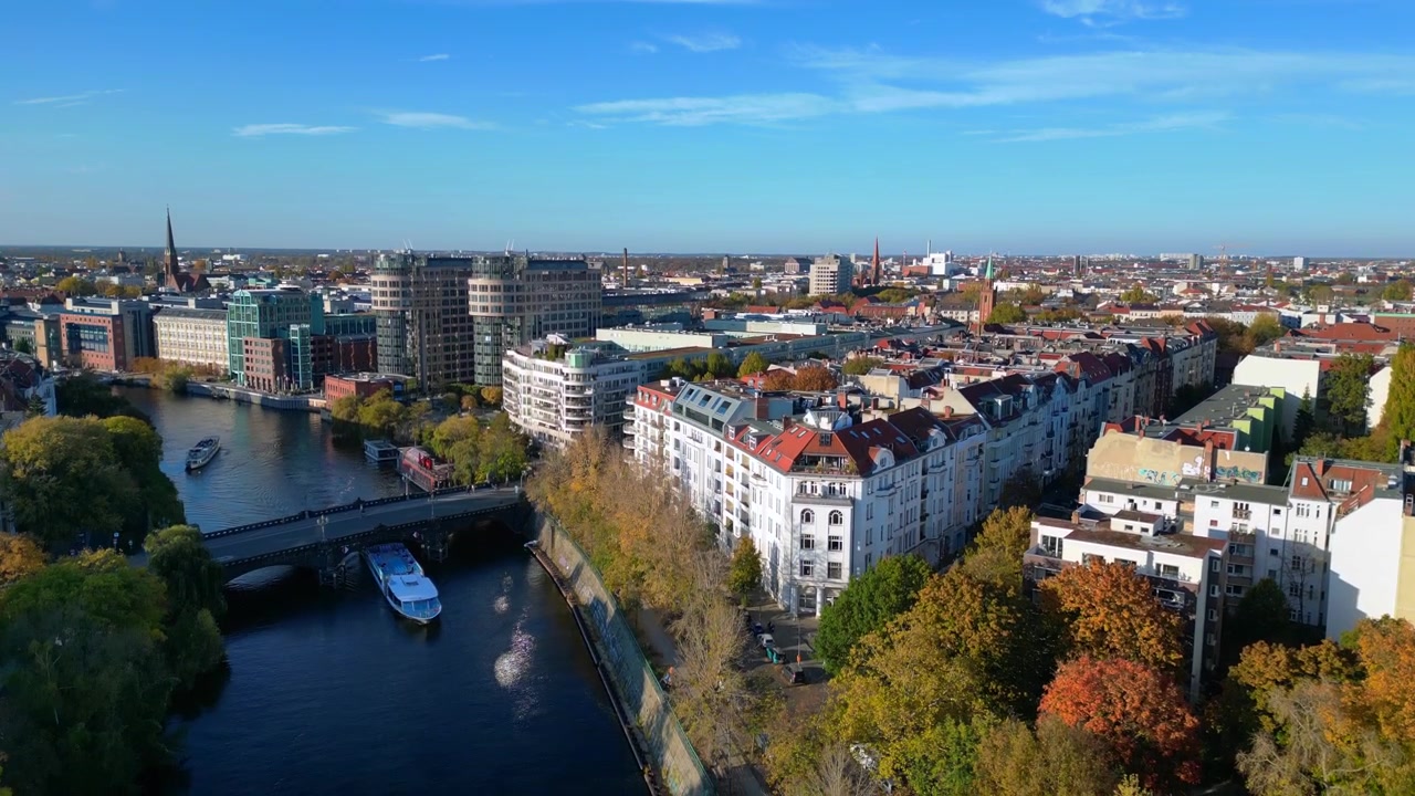 Landwehrkanal in Berlin, Deutschland, umgeben von Gebäuden und Herbstbäumen an einem sonnigen Tag. Großartige Luftaufnahme mit absteigender Drohne
