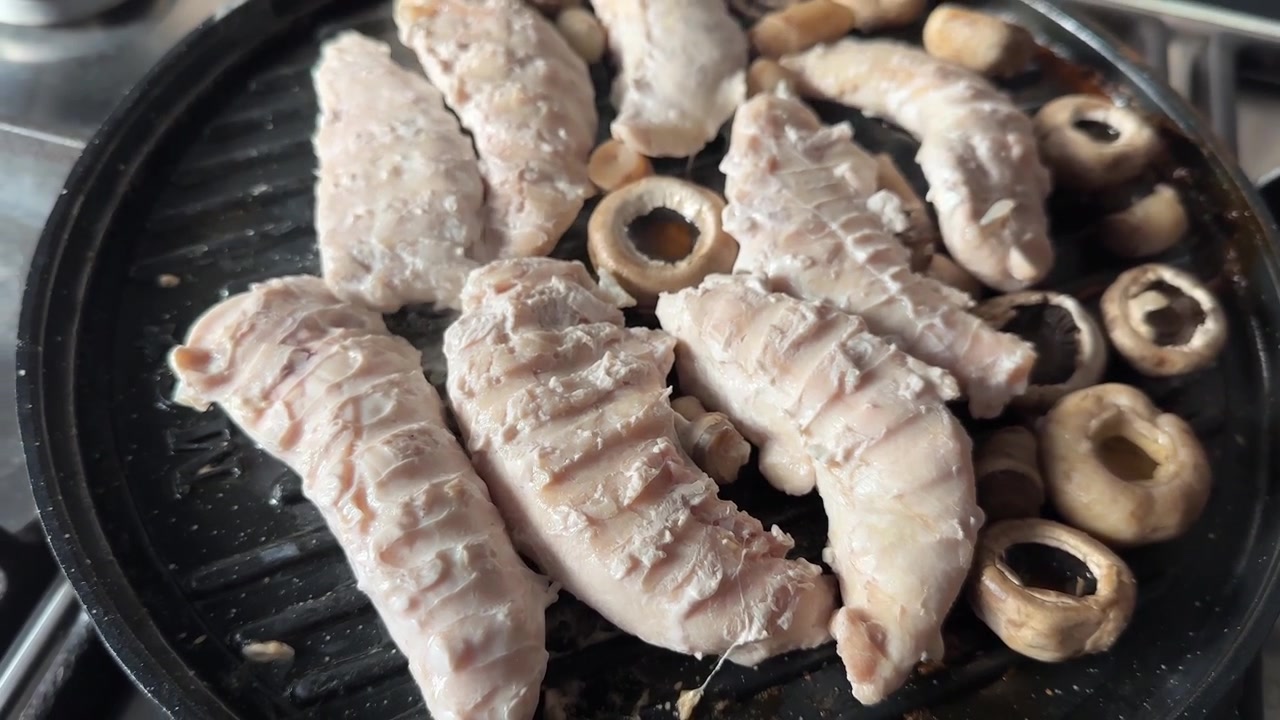 Filetto di pollo grigliato e arrostito con crosta scottata su piastra grill da fornello, brodo di funghi fumante e sfrigolante, e un saporito pasto proteico della cucina persiana fatta in casa in preparazione culinaria, primo piano di una cena in famiglia