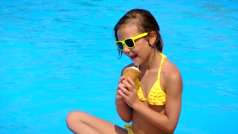 the child eats ice cream near the pool. selective focus. kid.