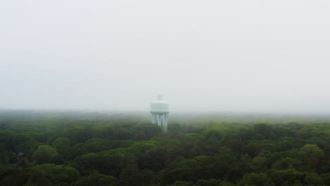 drone shot of water tower above trees with fog and mist weather hd 30p