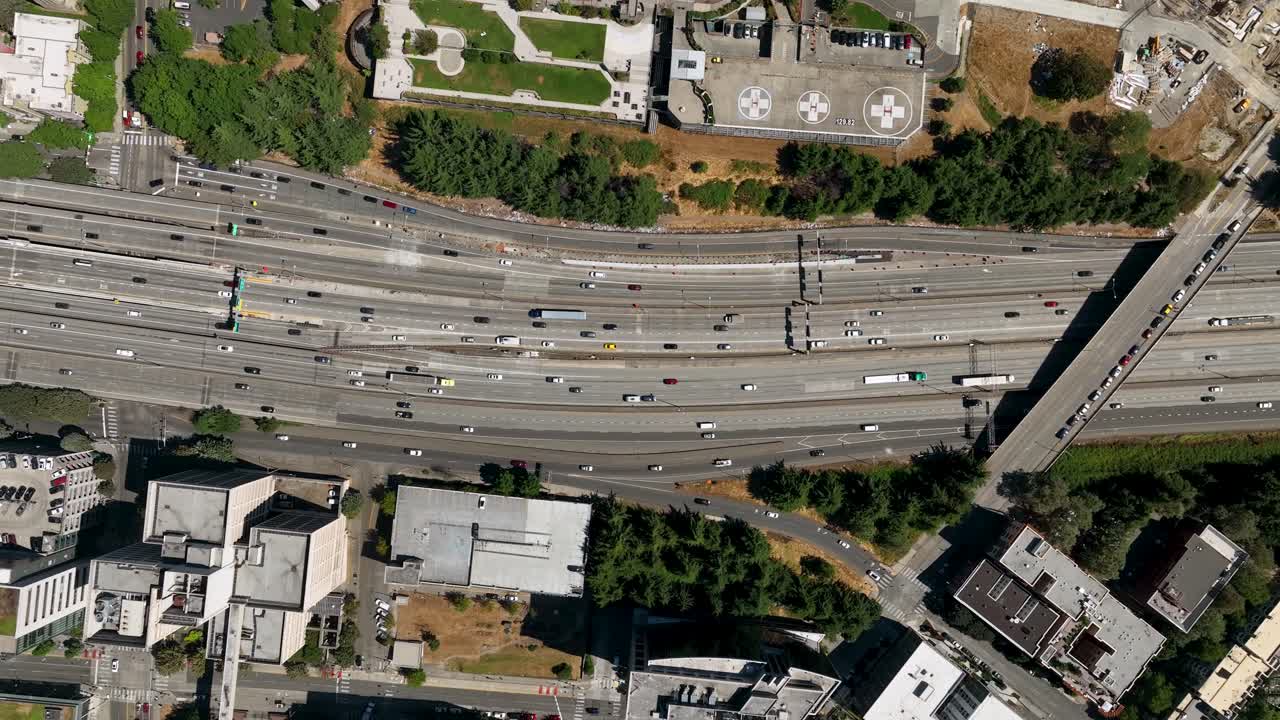 Lowering top down drone shot of traffic driving through Seattle's downtown freeways