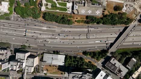 bajando de arriba hacia abajo toma de drone del tráfico conduciendo a través de las autopistas del centro de seattle