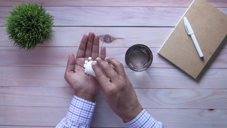 person taking pills with water