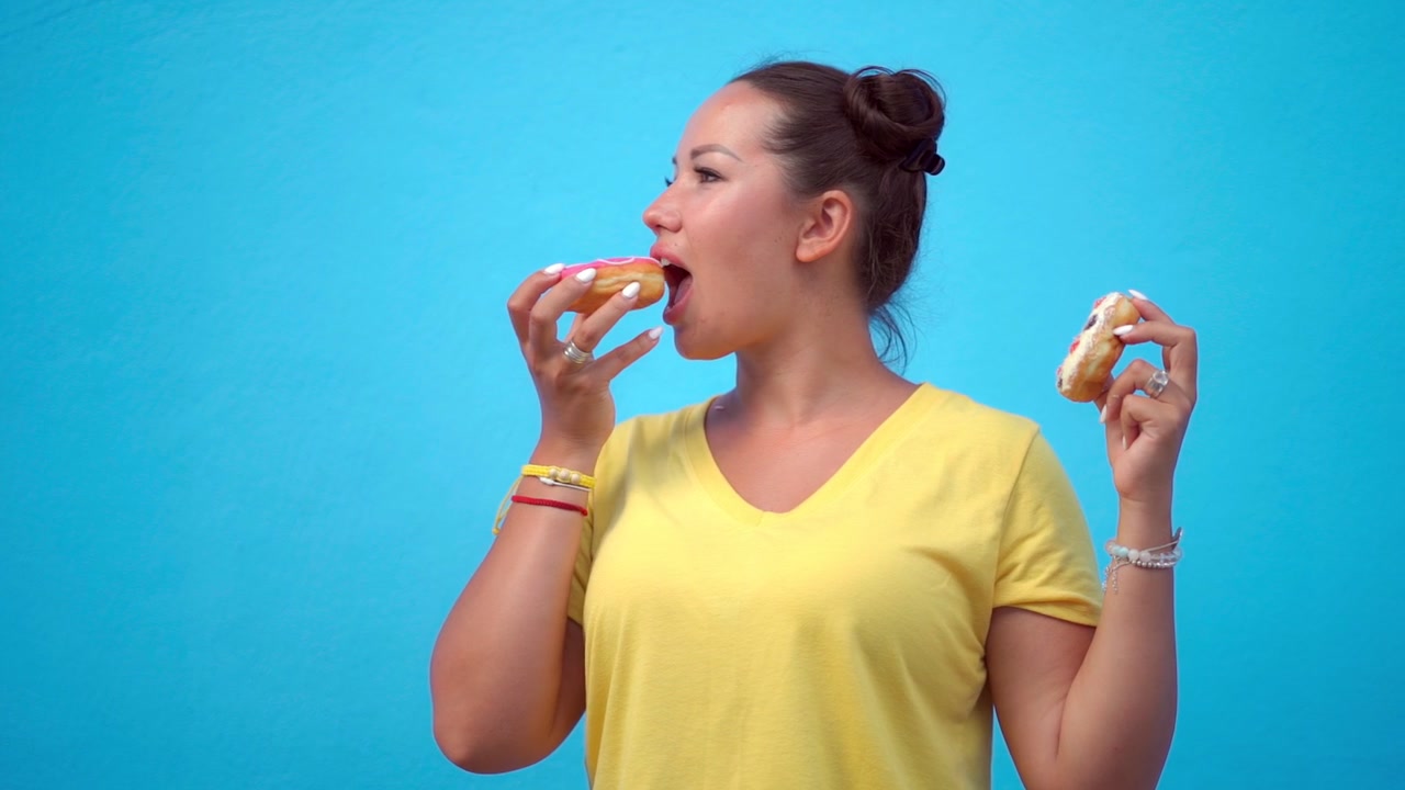 Young Woman Choosing Between Two Different Donuts
