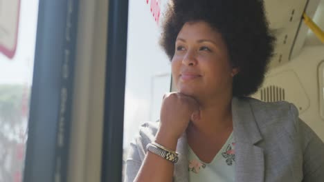 happy plus size biracial woman sitting in bus