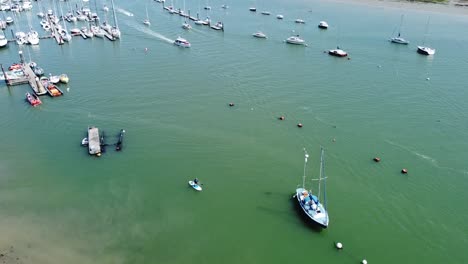 Birds-eye-view-of-boats-entering-and-leaving-the-marina-on-a-sunny-day-in-the-south-of-england