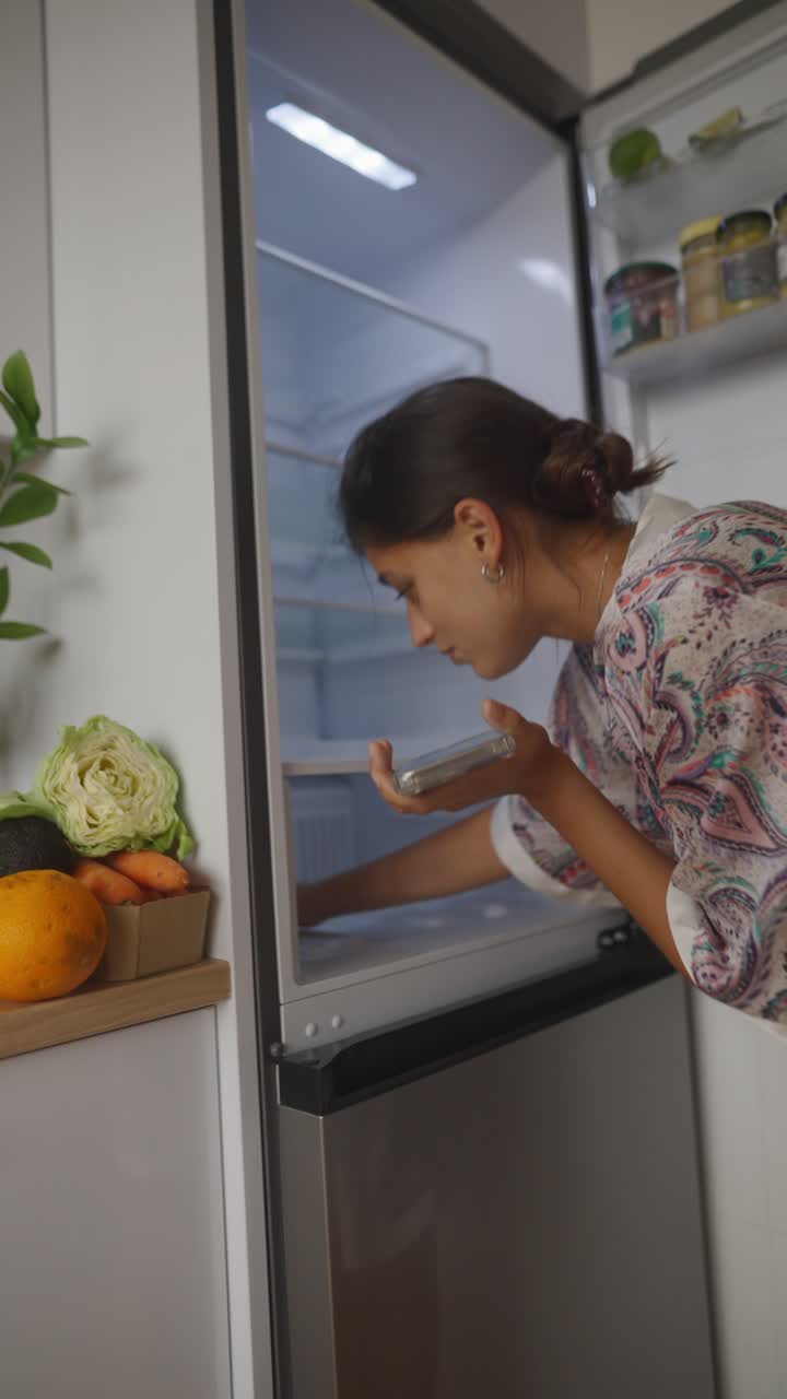 Woman Checking Refrigerator in Kitchen