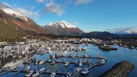 aerial view, drone ascending over harbor in late fall with snowcapped mountains in background, seward alaska