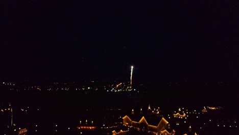 aerial view of multiple fireworks explosives and display on a quiet clear night as seen by a drone