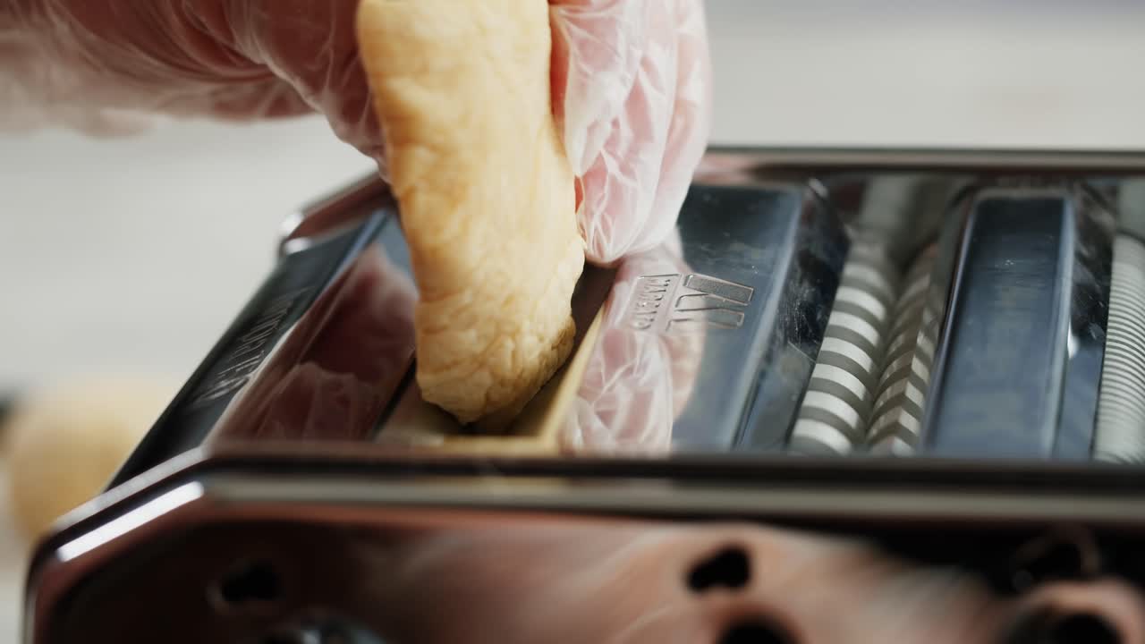 Close-up of Hands Making Fresh Pasta with a Pasta Machine