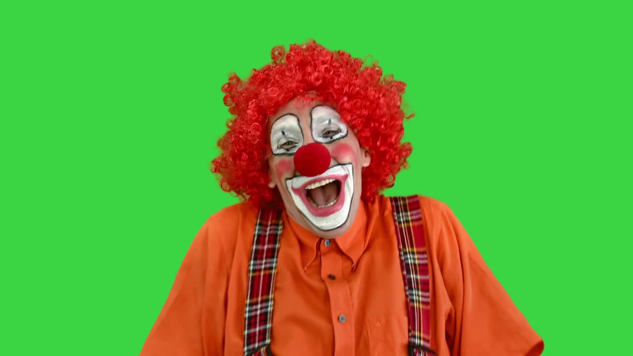 payaso gracioso soplando una pipa en una celebración en una pantalla verde, clave de croma