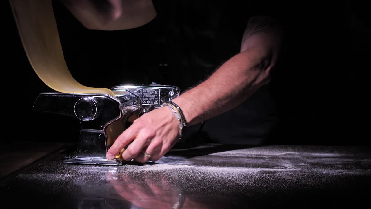 Process of making lasagne pasta rolling dough in pasta machine, close up