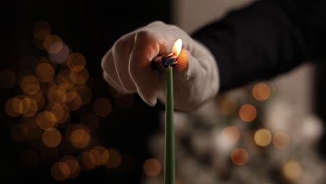 hand lighting a christmas candle