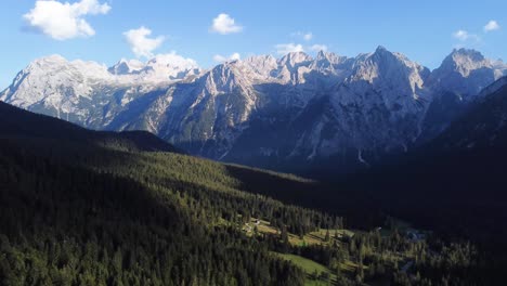 rotational 4k drone shot of a stunning valley full of pine trees with unique and outstanding mountain and rock formations in the background in the beautiful area of the dolomites in north italy