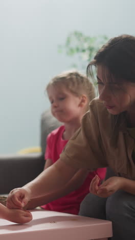 woman puts seeds into toddler son palm preparing for sowing in living room slow motion. family plants seedlings. gardening hobby and kids development